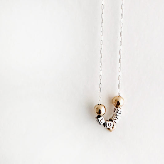 Delicate Sterling silver and 14k gold necklace that spells out the word love in sterling silver beads