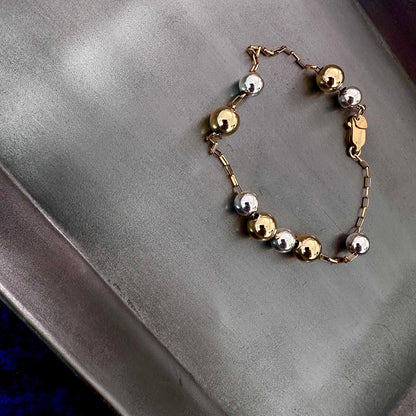 Mixed metal sterling silver and 14k gold bracelet with beads on gold chain float freely