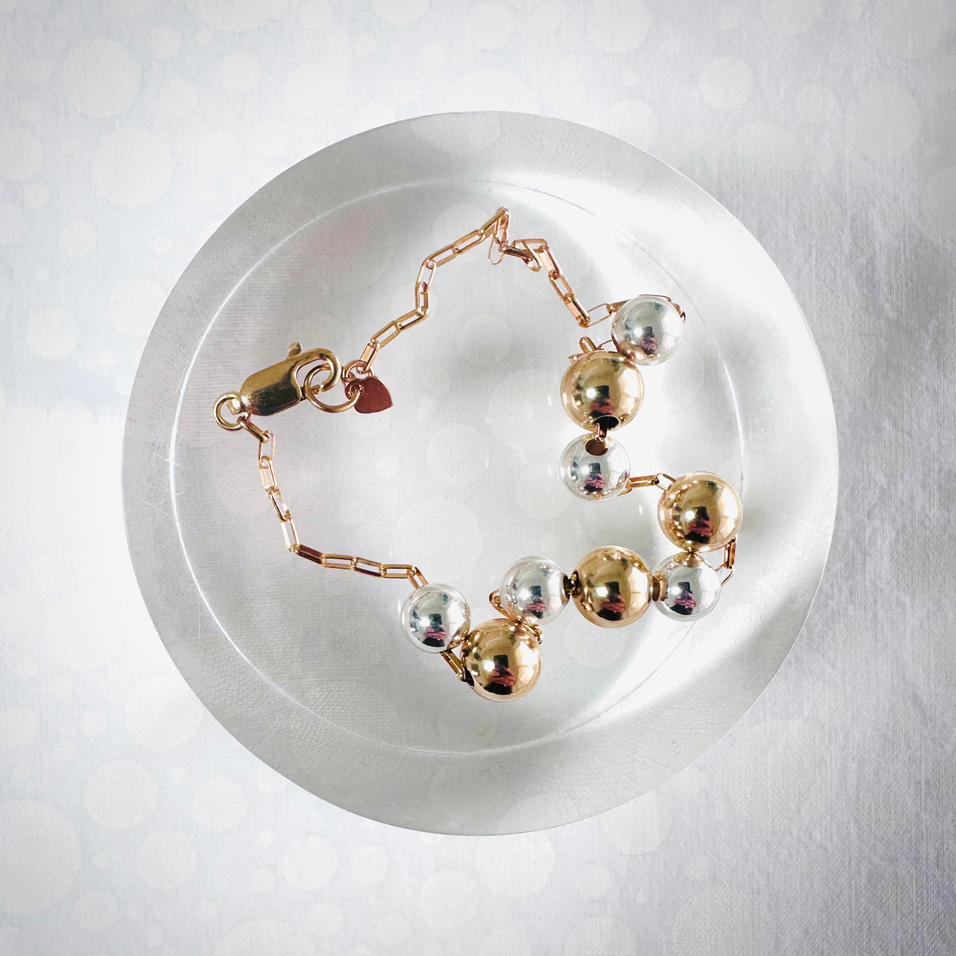 Delicate gold bracelet with silver and gold balls
