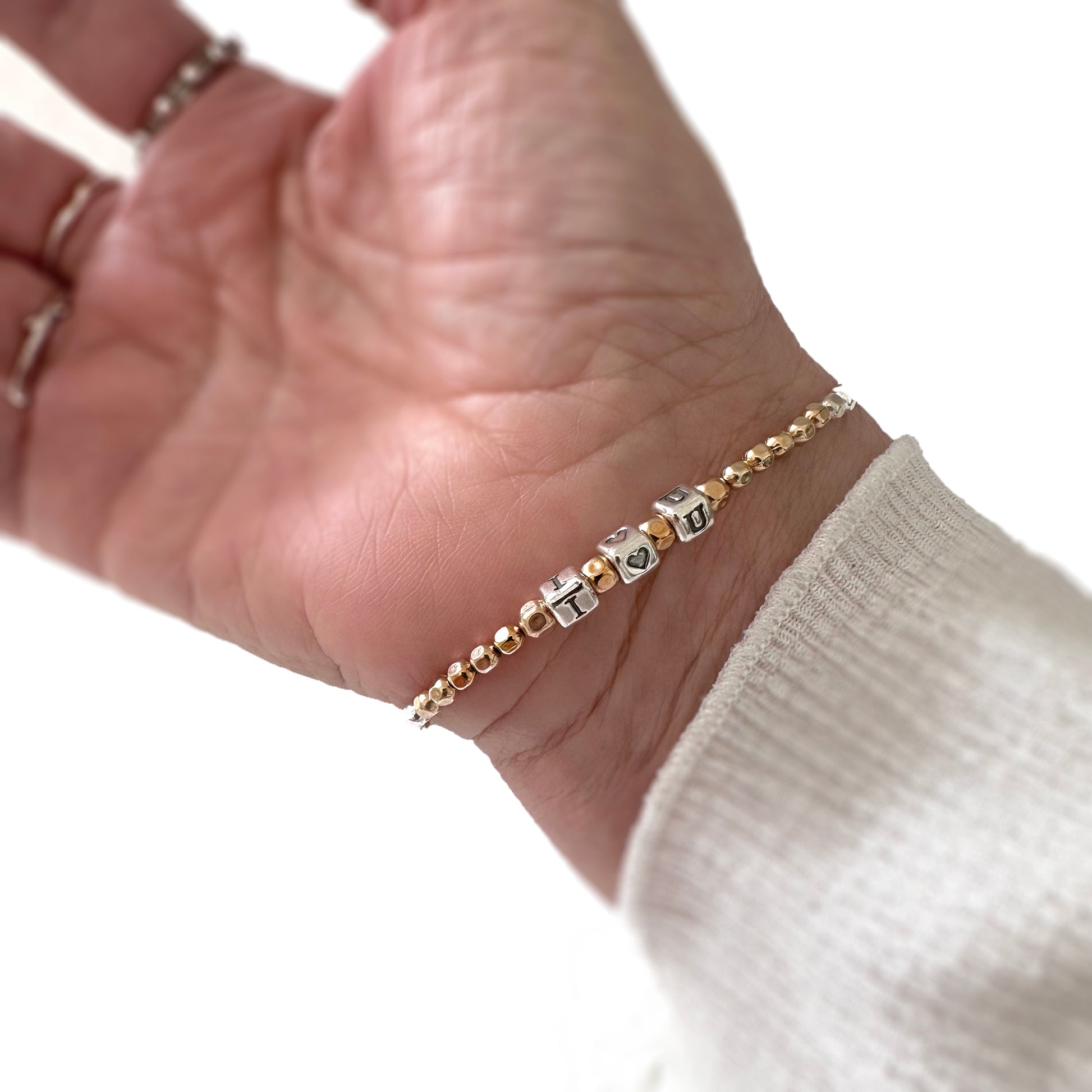 I Heart You Love Bracelet in Sterling Silver letters and 14k gold beads, shown on woman's wrist