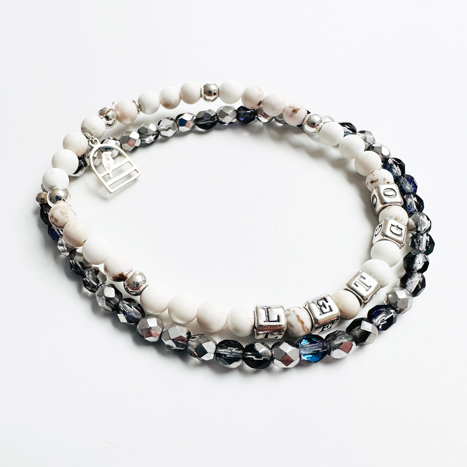 Let Go stretch bracelet in sterling silver and white howlite beads, with sterling silver bird charm and sparkly crystal stretch bracelet