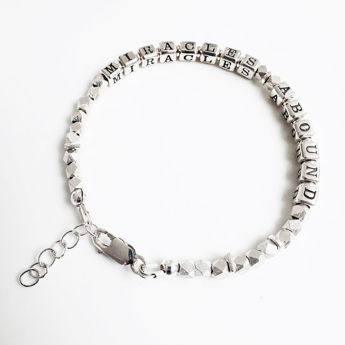 Sterling Silver bracelet spelling out the message "Miracles Abound" and has adjustable closure