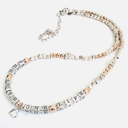 Necklace with letter beads that spell One Love One Life in sterling silver and 14k gold
