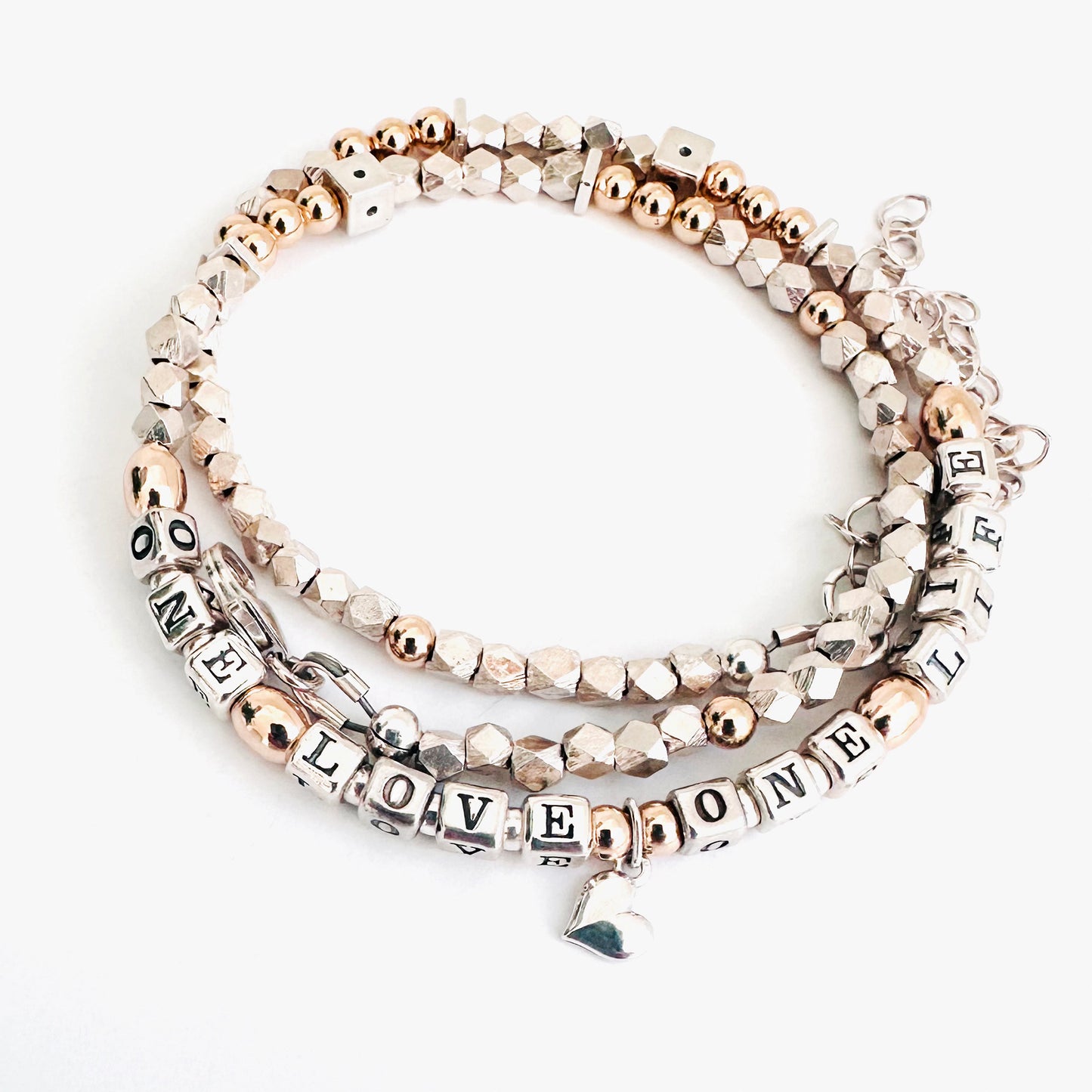 Necklace wrapped as bracelet, with letter beads that spell One Love One Life in sterling silver and 14k gold and a silver heart