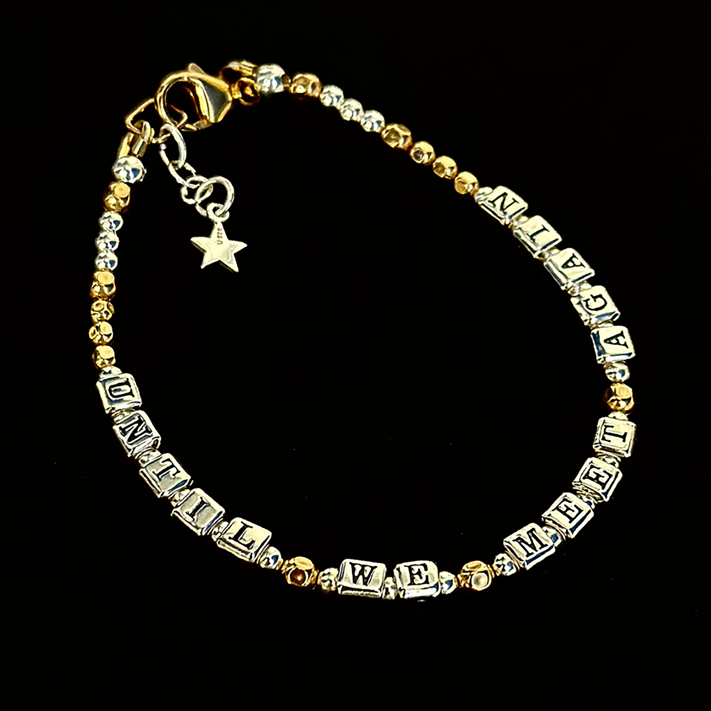 Sympathy or Grief Gift Bracelet says "Until We Meet Again" in sterling silver and gold, shown on black background