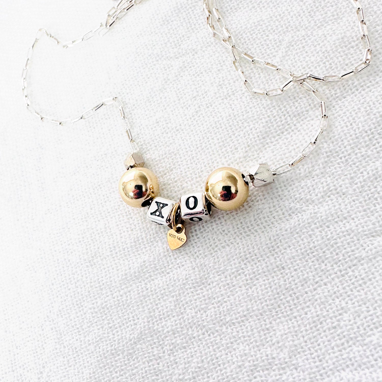Delicate necklace with sterling silver and 14k gold beads and heart, spells out XO for hugs and kisses