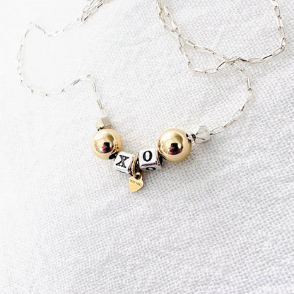 Delicate necklace with sterling silver and 14k gold beads and heart, spells out XO for hugs and kisses
