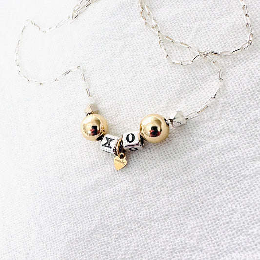 Delicate necklace with sterling silver and 14k gold beads and heart, spells out XO for hugs and kisses