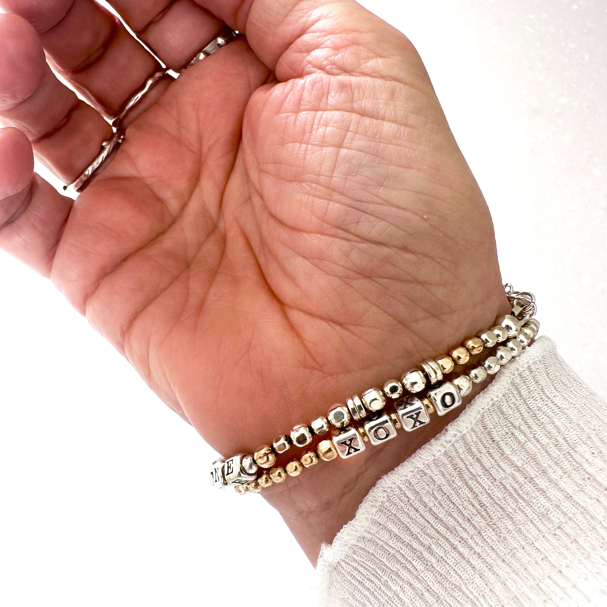XOXO love and friendship bracelet in sterling silver and 14k gold filled beads, shown on wrist
