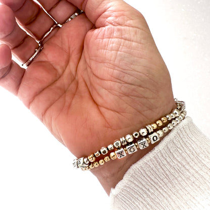 XOXO love and friendship bracelet in sterling silver and 14k gold filled beads, shown on wrist
