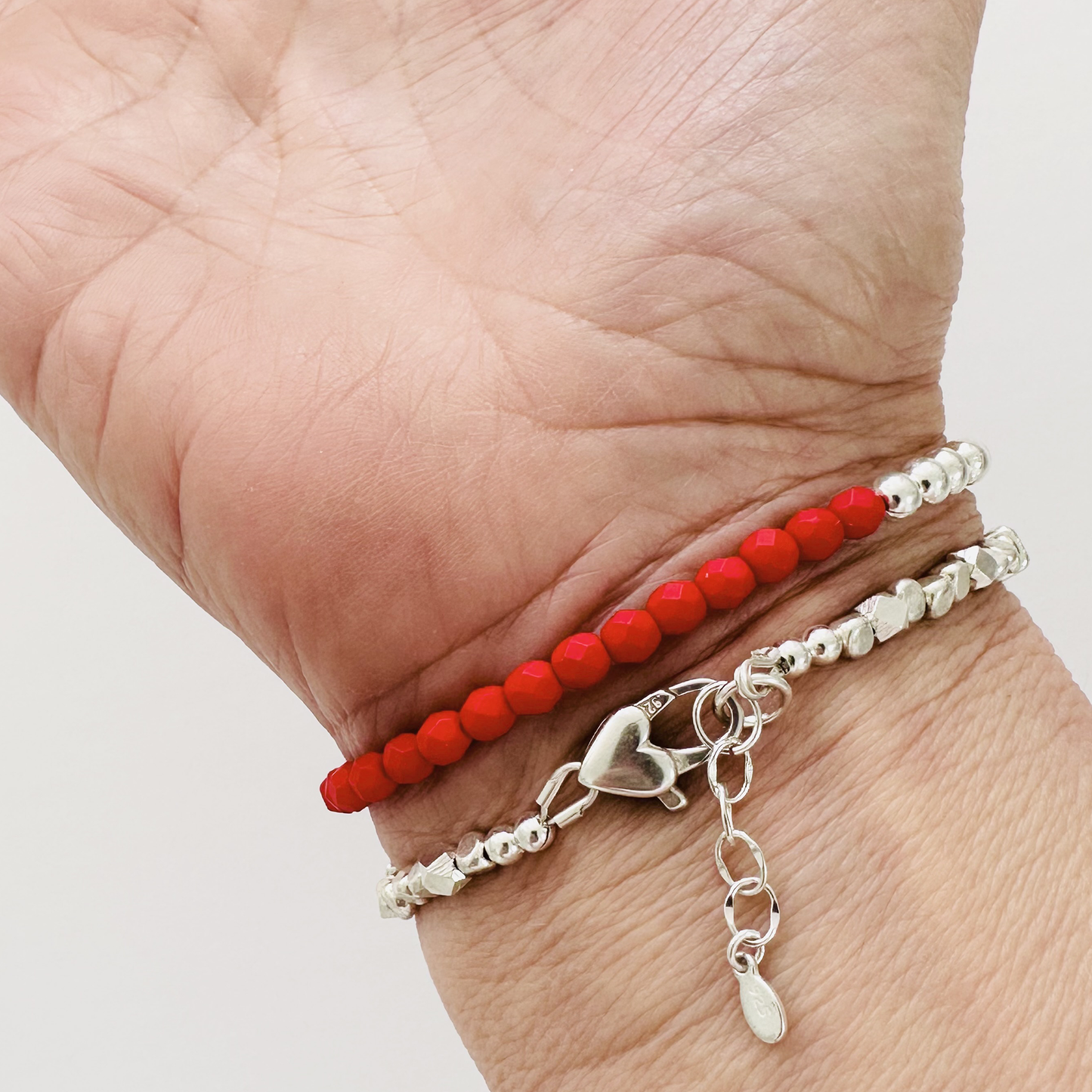 Beloved Love Bracelet with sterling silver heart clasp and red beaded bracelet, shown on woman's wrist