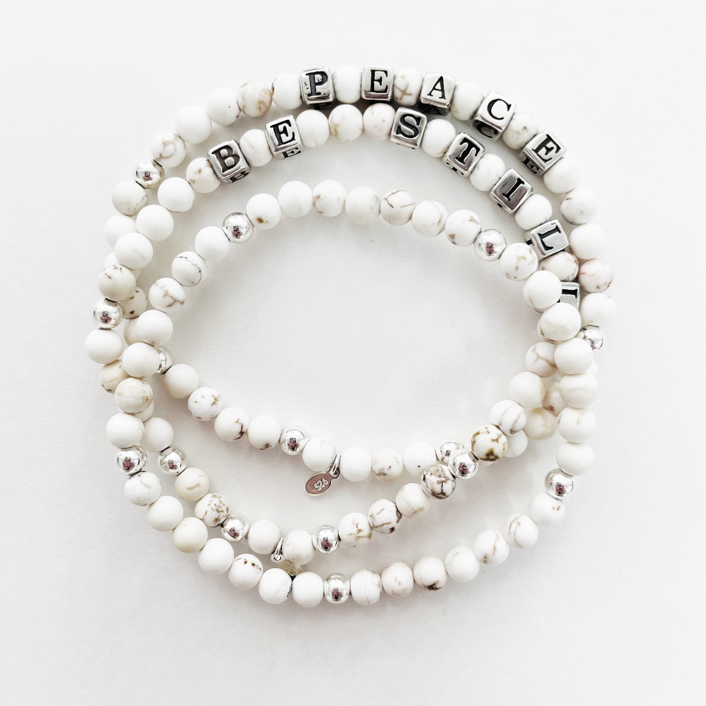 Be still sterling silver and white howlite beaded bracelet shown with Peace message bracelet in white howlite and sterling silver